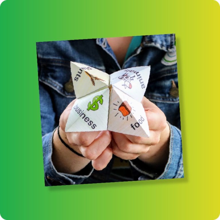 Student in jean jacket holding agriculture fortune teller on green and yellow gradient background